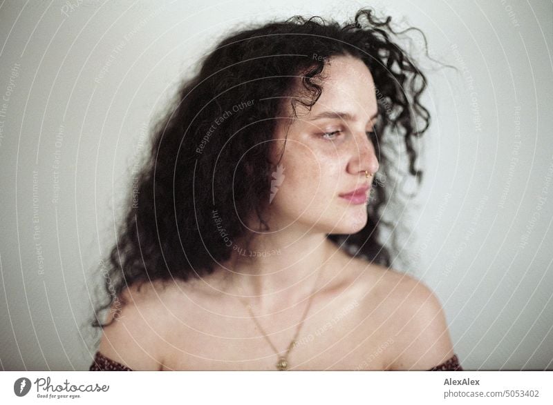 Close side portrait of young dark haired woman with curls, light blue eyes and freckles Woman Young woman Freckles Curl Brunette long hairs pale pretty Skin