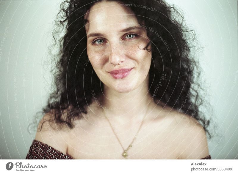 Close portrait of young dark haired woman with curls, light blue eyes and freckles Woman Young woman Freckles Curl Brunette long hairs pale pretty Skin Face