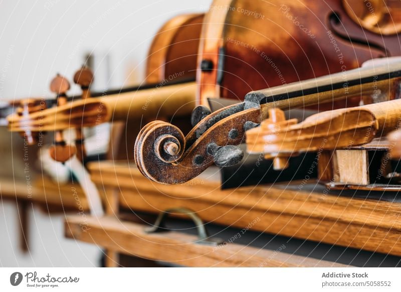 Hand carved scrolls of violins on shelf in workshop instrument tool craft art wooden luthiery woodworking craftsman production manufacture professional handwork