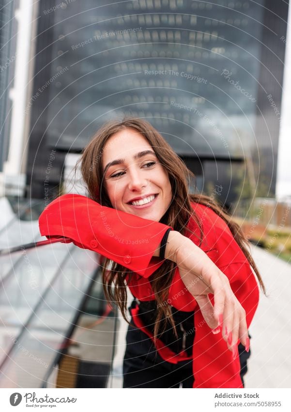 Cheerful young female leaning on border woman smile street urban style happy appearance brunette brown hair shirt glad modern cheerful barrier positive park