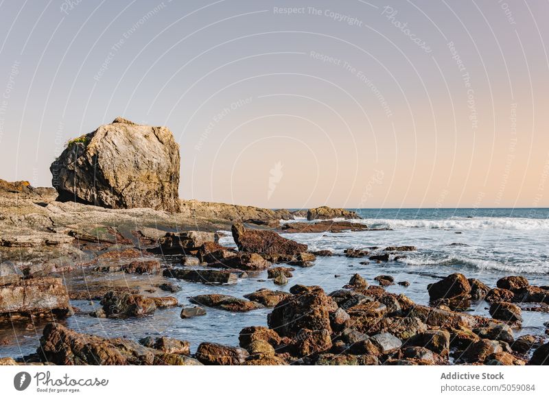 Beach and sea against sundown sky shore wave rock sunset cloudless sky evening boulder rough weather alkolea beach mutriku gipuzkoa spain ocean twilight water