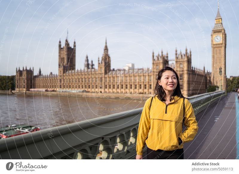 Asian woman on bridge over river smile tourist happy visit explore weekend landmark london uk united kingdom england big ben palace of westminster thames