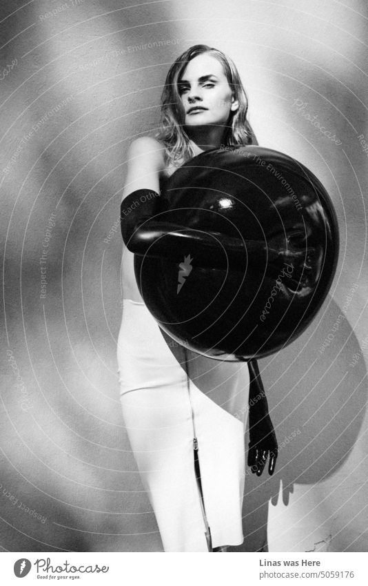 A real beauty dressed in a latex skirt with latex gloves. And that’s probably it. While holding a big black balloon next to her chest she is making this model test feel really intimate. The black & white image supports the mood just fine.