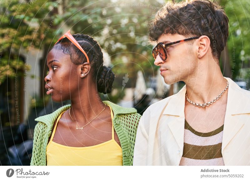 Stylish diverse couple holding hands and walking on street crosswalk city together cool love style confident relationship road boyfriend girlfriend young