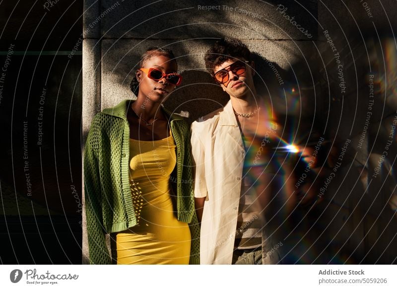 Trendy young multiethnic couple standing near building on city street selfie style together confident relationship cool take photo reflection love millennial