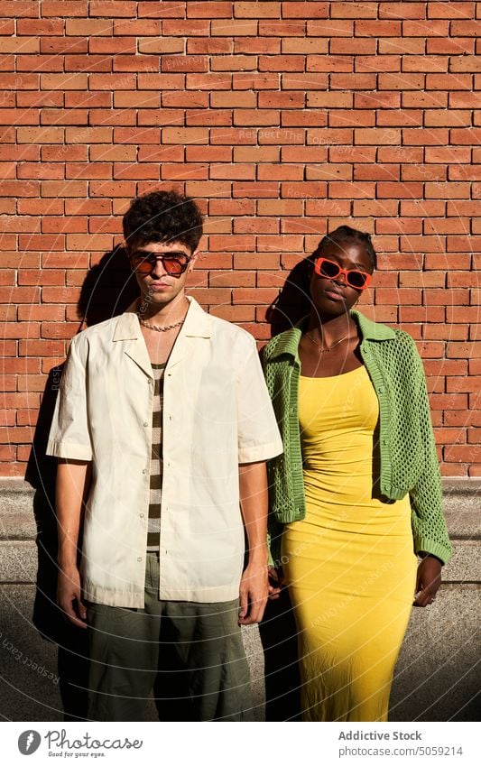 Stylish diverse couple looking at camera on street in daylight spend time relationship trendy style glamour together soulmate partner wall summer gorgeous