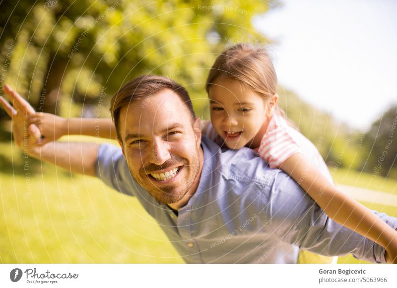 Father with daughter having fun at the park back beautiful beauty caucasian child childhood closeness dad day enjoying expressions exterior family father