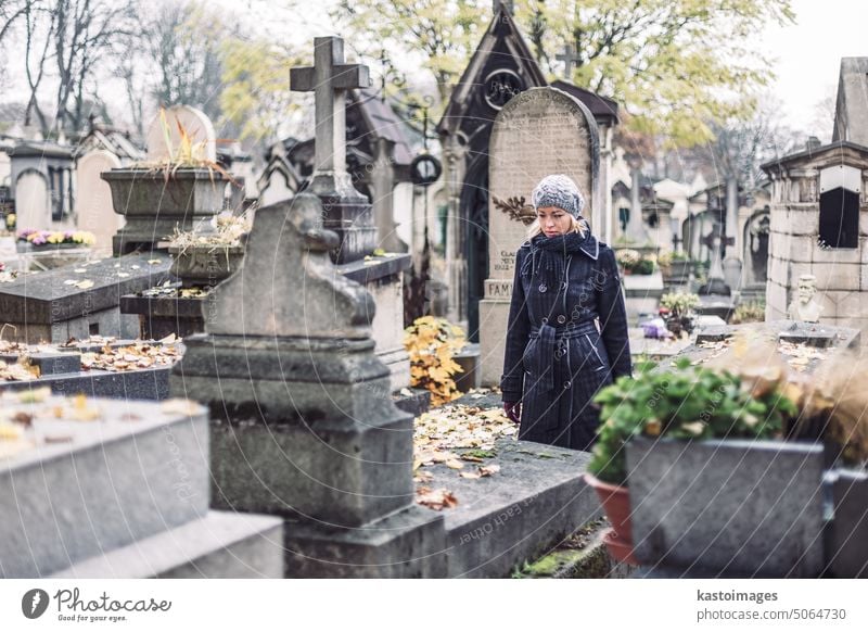 Solitary woman visiting relatives grave. cemetery memorial sadness stone tombstone death female graveyard remembrance person lonely caucasian beautiful grief