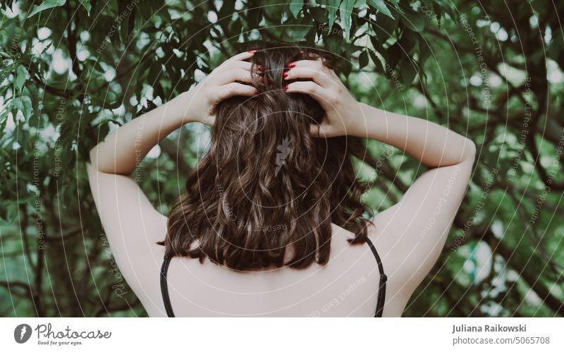 Woman with brown curls in forest Lifestyle Stand Nature youthful Spring Summer Serene closeness to nature Environmental protection Esthetic Hair and hairstyles