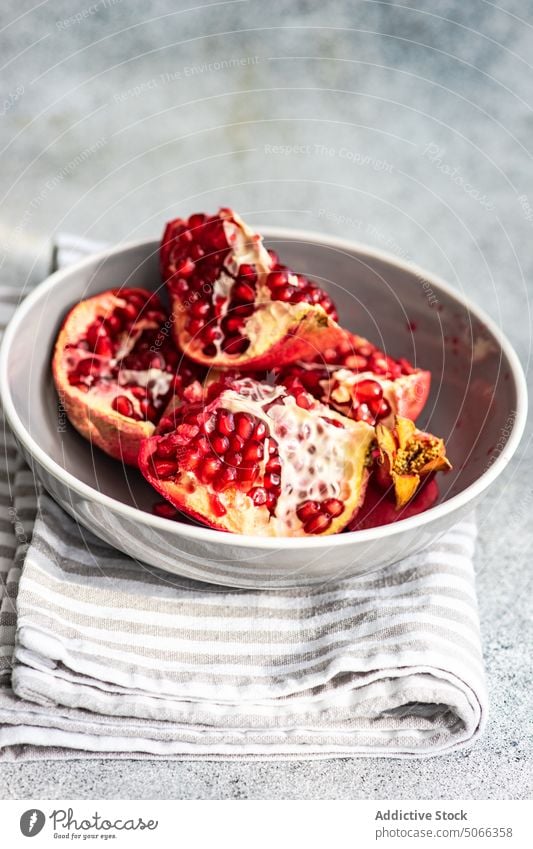 Ripe organic pomegranate fruit background ceramic concept dessert diet eat food grey half healthy modern napkin concrete nature piece plate red ripe rustic seed