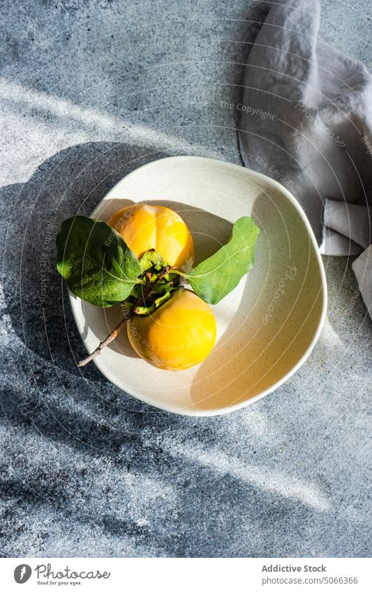 Autumnal place setting Diospyros bowl branch ceramic concrete dinnerware fall fresh fruit harvest organic persimmon ripe table tableware autumn market food