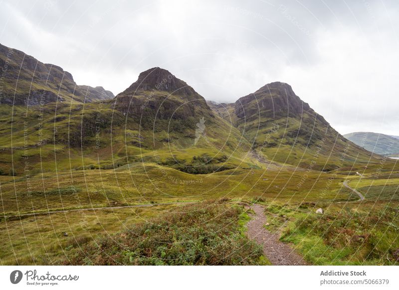 Green valley near mountains in highlands overcast range landscape nature path breathtaking green gray glen coe scotland uk united kingdom weather geology slope