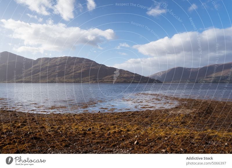 Lake and mountains against cloudy sky lake shore nature blue sky ridge seaweed water daytime scotland uk united kingdom scenery rock picturesque season