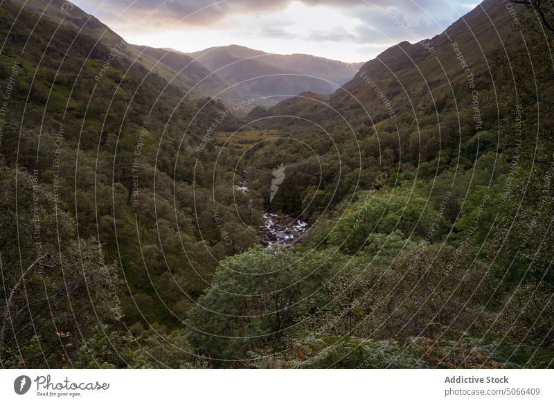 Cloudy sundown sky over valley mountain river cloudy sunset lush tree green evening scotland scottish highlands uk united kingdom landscape overcast nature