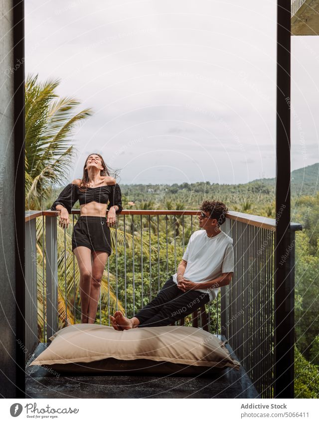 Couple resting on terrace of tropical resort couple vacation hotel balcony chill travel summer holiday enjoy relax together exotic boyfriend girlfriend