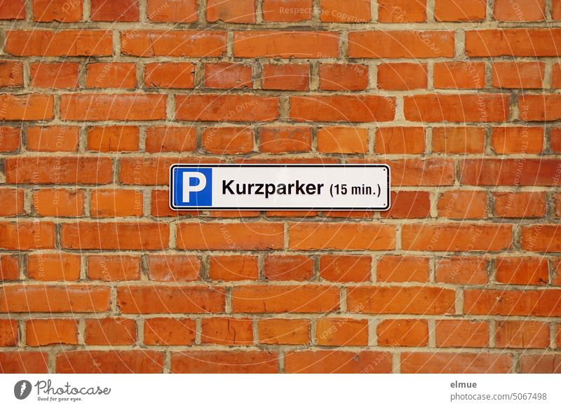 Sign - P short term parking (15 min.) - on a red brick wall Parking lot short-time parkers Parking restriction Bread roll fetcher sign Parking sign