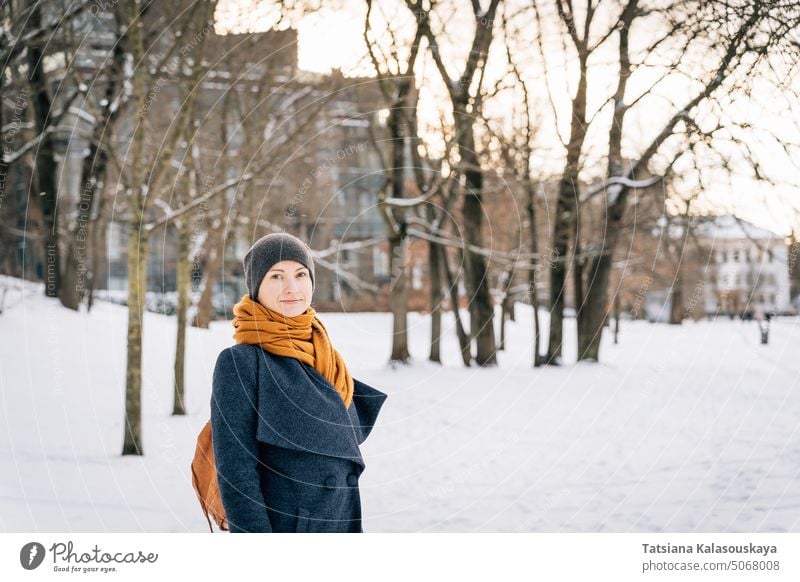 A woman on the street of a winter city looks into the camera cold snow happiness happy joy female people person adult coat Single person smile cheer Lifestyles