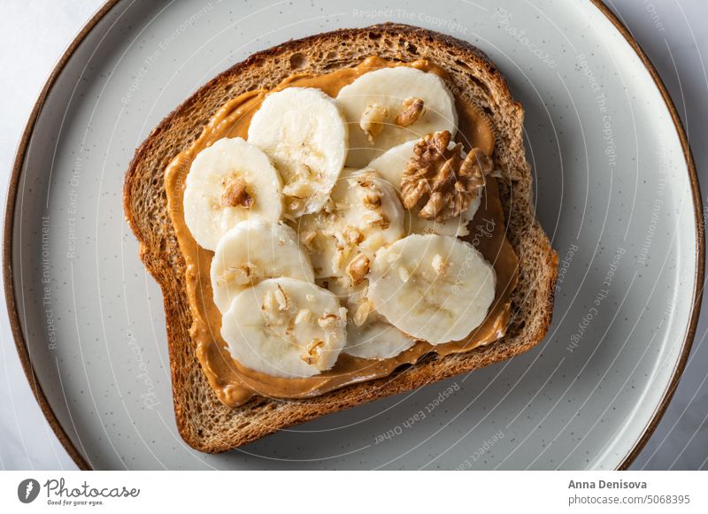 Healthy open sandwich with peanut butter healthy bread banana snack almond cashew wholegrain bread appetizer rye tasty toast overhead lunch board eating vegan