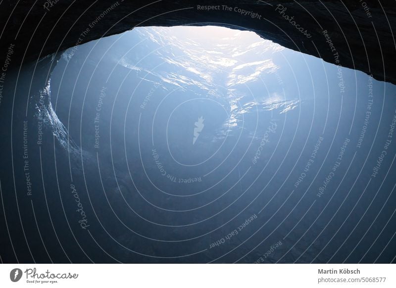 Rock cave with hole through which light shines. Underworlds in Sweden. Mystical sunlight travel vacation tunnel danger national park fascination unique