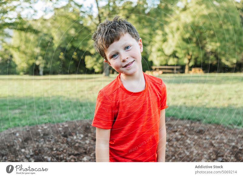 Glad boy in summer park smile positive daytime lawn weekend portrait appearance preteen t shirt child happy childhood cheerful optimist friendly kid casual