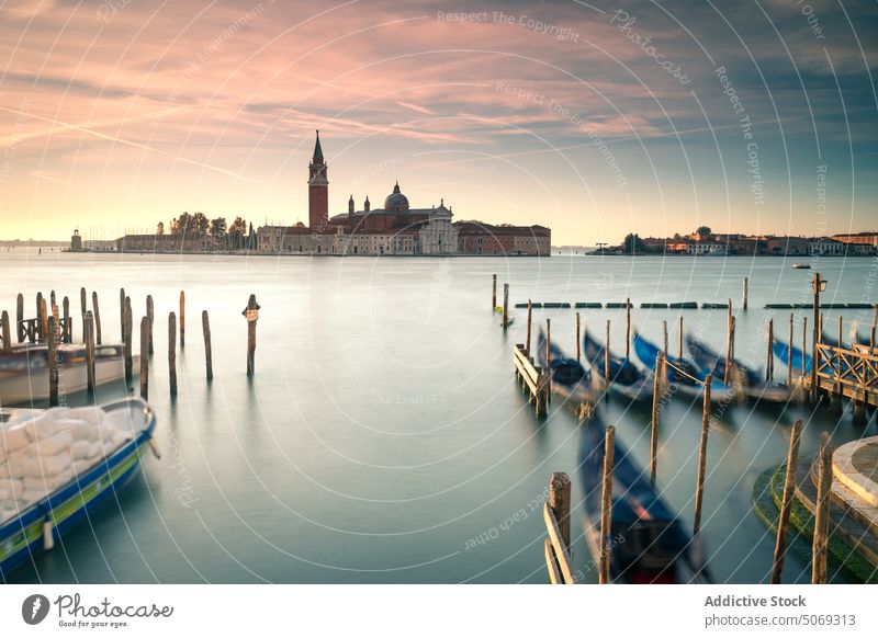 Gondolas on water near island with church gondola sunset sky cloudy float travel evening venice italy san giorgio maggiore san marco basin shore coast tradition