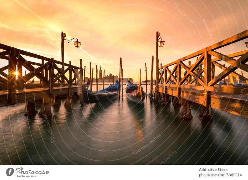 Gondolas moored near piers at sunset gondola sky cloudy tradition evening canal water venice italy san marco basin boat transport landmark dusk twilight