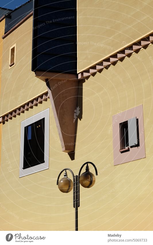 Geometric architectural accents in a modern facade in yellow and beige in the sunshine as part of Goethehöfe on Großer Hirschgraben with street lamp in downtown Frankfurt am Main in Hesse, Germany