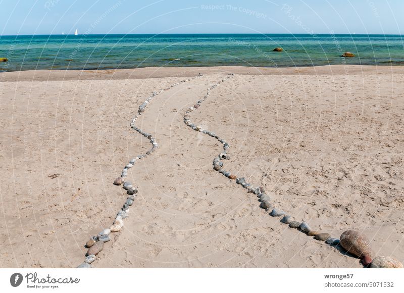 Beach path to the water lined with natural stones Baltic beach Baltic Sea Ocean off Boulders Horizon Sailboat Cloudless sky Sky coast Vacation & Travel