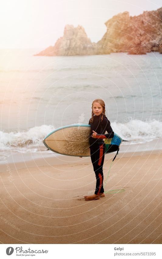 Small surfer with surfboard surfing child sunset horizontal wave sand sport blond adventure beach outdoor sea summer travel freedom joy lifestyles