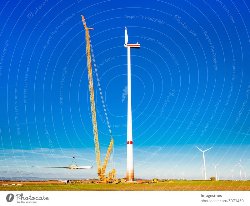 Construction site. Erection and assembly of a wind turbine by crane. Construction work at the wind turbine in Wörrstadt wind farm, Germany. Energy crisis concept, wind turbine construction