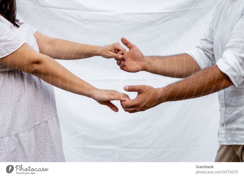 Pregnant woman and her husband touching each others fingers couple hands romantic pregnant pregnancy tummy outdoor happy concept belly Caucasian family