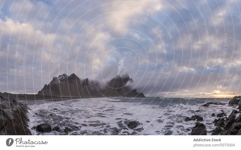 Amazing view of stormy sea and mountains wave nature landscape scenery picturesque cloudy sky coast shore snow iceland stockness beach rough water seashore