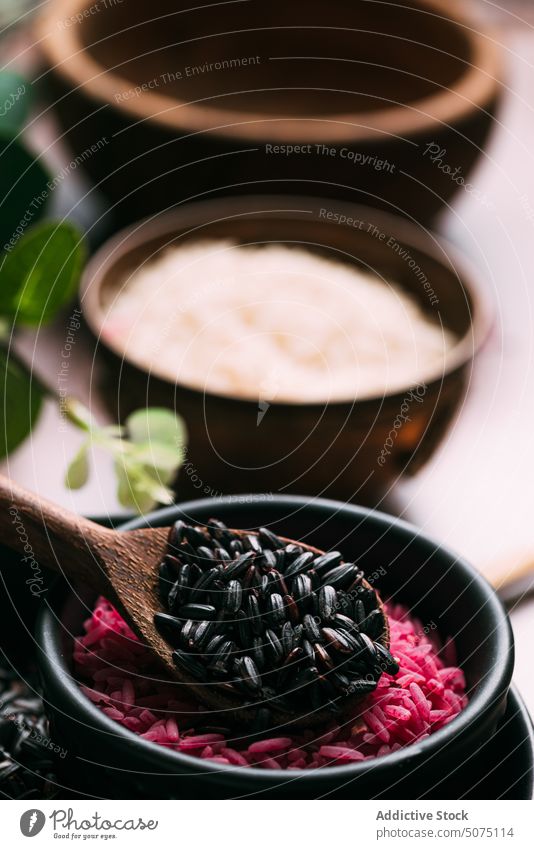 Assorted rice in bowls near eucalyptus twigs assorted natural ingredient table fresh organic vegetarian nutrition composition white black pink diet raw