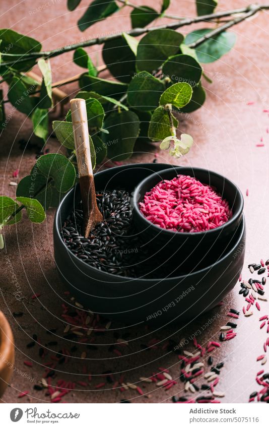 Assorted rice in bowls near eucalyptus twigs assorted natural ingredient table fresh organic vegetarian nutrition composition white black pink diet raw