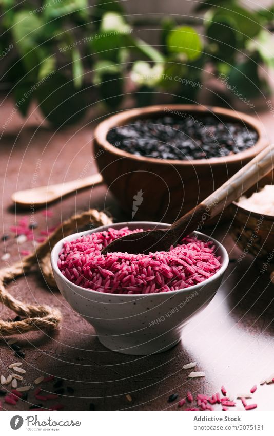 Assorted rice in bowls near eucalyptus twigs assorted natural ingredient table fresh organic vegetarian nutrition composition white black pink diet raw