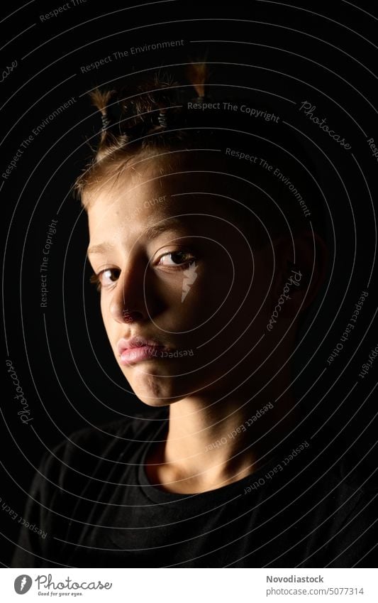 Portrait of a 9 year old boy with ponytails, dark background Portrait photograph Boy (child) isolated person Hair and hairstyles Ponytail pigtails