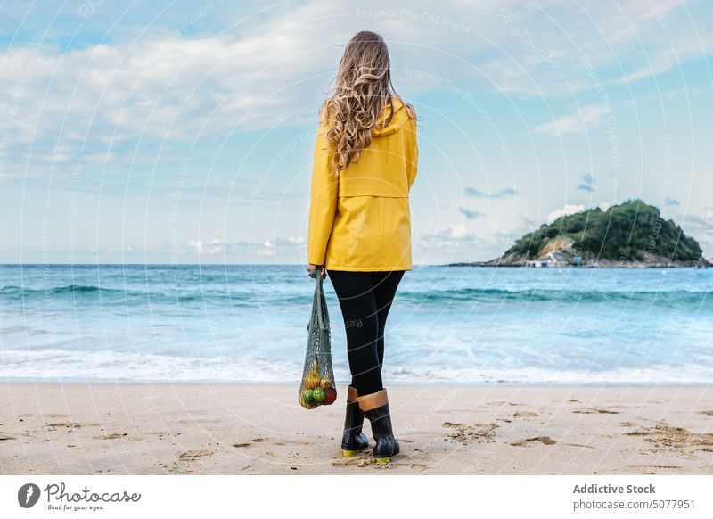 Woman with fruits in bag admiring beach woman wave sea standing sandy water apple organic female coast donostia vacation admire nature spain wet tourist weekend