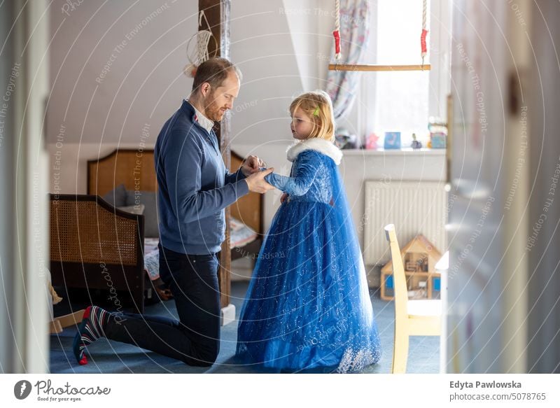 Father playing with his daughter at home modern manhood genderblend real life real people bonding family indoors quality time house parenting kids enjoyment