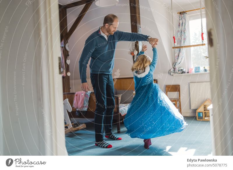 Father playing with his daughter at home modern manhood genderblend real life real people bonding family indoors quality time house parenting kids enjoyment