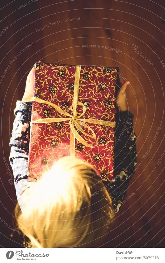 Child holds a gift in his hands for Christmas Gift stop Joy Giving of gifts Birthday celebrations Donate Christmas gift Surprise Anticipation