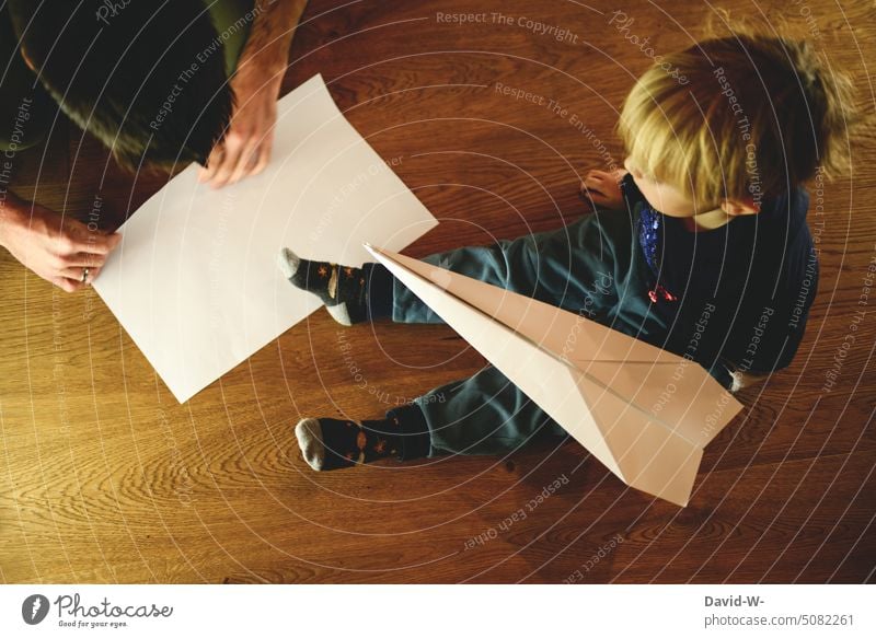 Father and son tinkering together Father with child dad Son Handicraft at the same time in common Parents Paper plane Creativity Together Playing