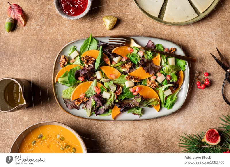 Plate with vegetarian salad for lunch pumpkin spinach lettuce vegan vegetable plate healthy food serve seed pomegranate walnut sauce berry soup cheese fig acorn