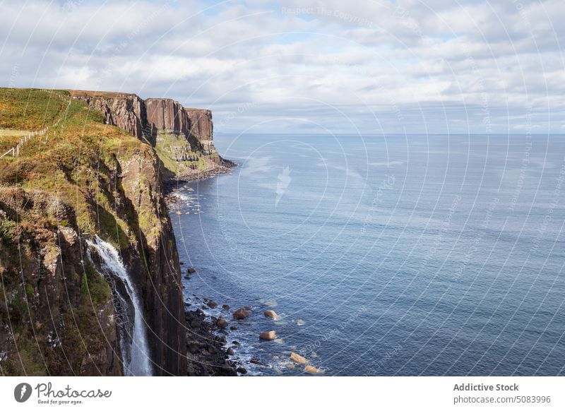 Rocky cliff with waterfall near sea scenery rocky cloudy sky nature breathtaking skye island scotland europe magnificent deep aqua ocean marine seashore uk