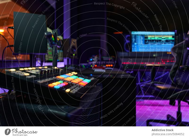 Modern recording studio with equipment glow neon light ring lamp video camera mixer computer workplace music sound window audio column purple orange melody tune