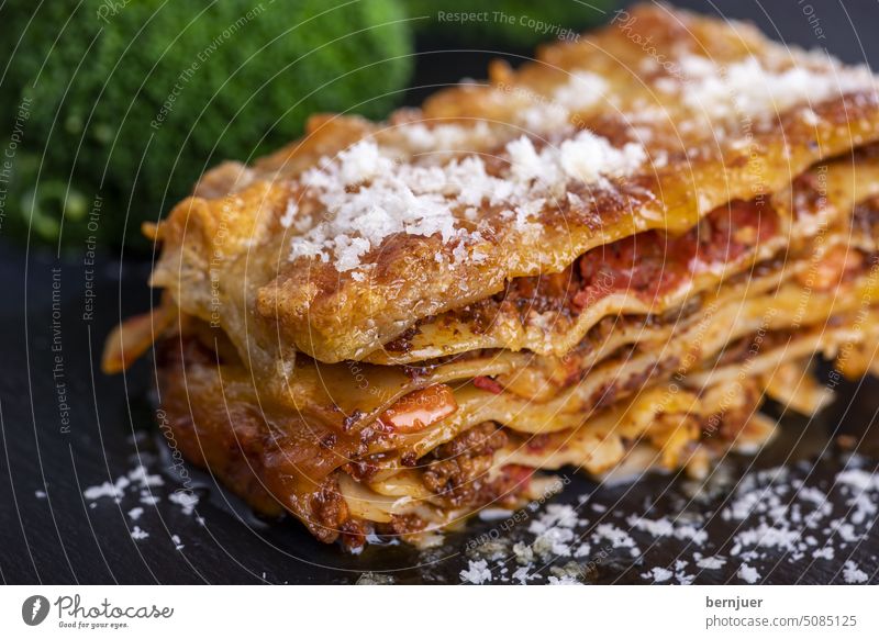 Lasagna on slate with broccoli Lasagne Slate Broccoli Stone Basil Plate Tomato baked Italian Table Bolognese pasta Cheese sauce Parmesan tribunal Mediterranean