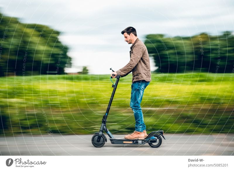 Man riding the e-scooter electric scooter e-roller Driving swift Speed fun Sustainability Eco-friendly Innovative Nature out Street Mobility