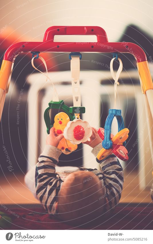 Baby under a play arch Child Playing Play arch motor function motor skills inquisitive inquisitorial explore Grasp hands Observe Toys Sense of touch youthful