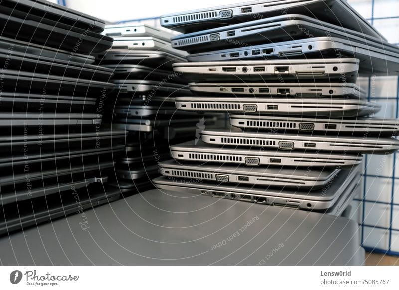 Big stacks of discarded laptops, notebooks on a trolley broken damaged e-waste electrical equipment electronic waste electronics industry environment garbage