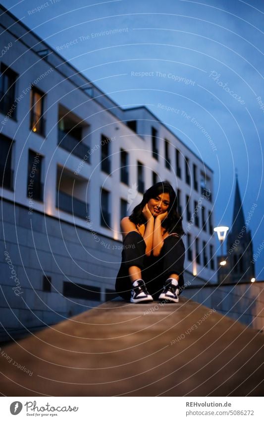 Young woman sitting on a wall in the city Woman Town Evening Adults Twilight Exterior shot Human being portrait pretty Fulda Shallow depth of field Authentic