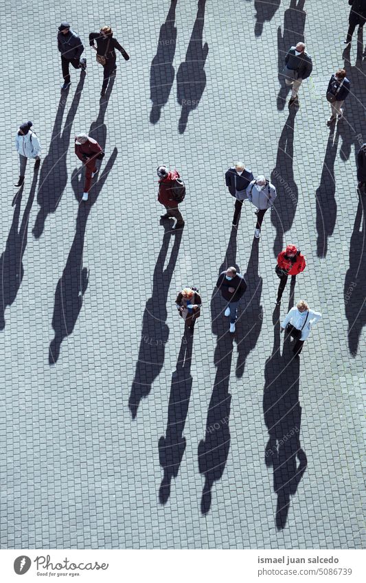 large group of people walking on the street in Bilbao city, spain crowd tourists tourism person human pedestrians shadow silhouette ground outdoors urban